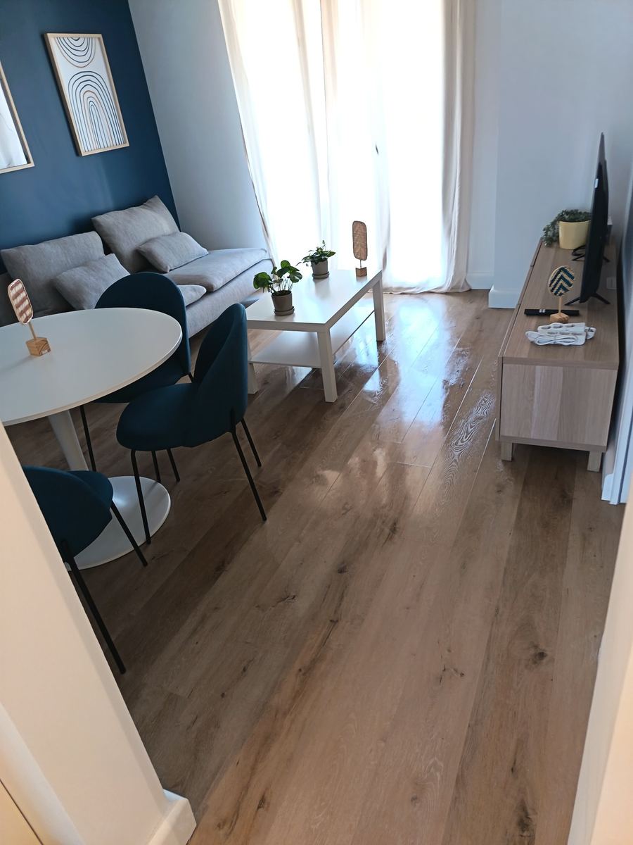 Séjour propre avec mur bleu et parquet brillant